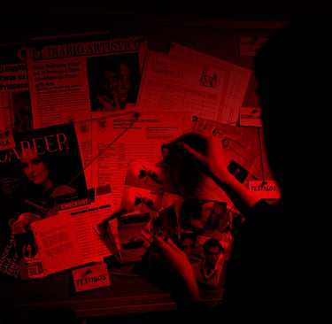A silhouette of a detective pinning photos to a crime investigation board under intense red light.