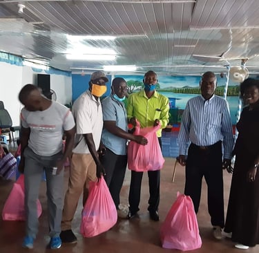 Volunteers distributing pink bags of food and supplies in Kisumu.