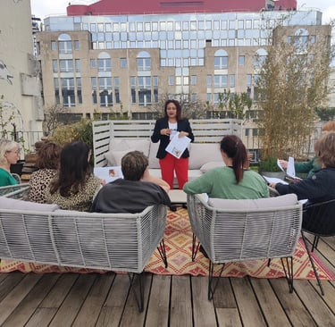Groupe d’élèves assis sur une terrasse, suivant une formation dirigée par une formatrice.