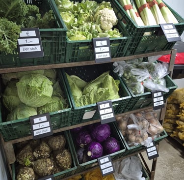 Verse groenten liggen netjes in de schappen van de boerderijwinkel Hoeve Dinjens in Maastricht