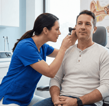 exploración de oído de una otorrinolaringóloga a paciente en consultorio médico