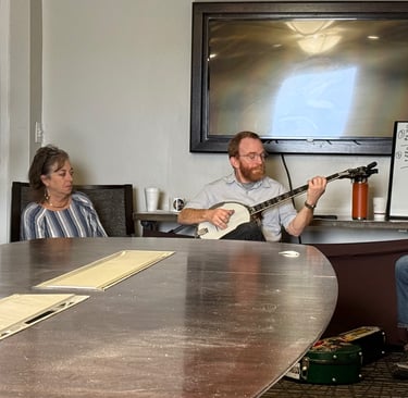 Mark Delaney holding a banjo while teaching a banjo workshop