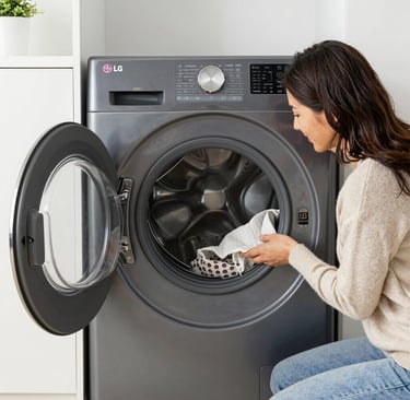 Technician performing maintenance on a front-load Samsung washer and dryer set.