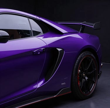 Side profile of a metallic purple luxury sports car featuring carbon fiber accents and black alloy wheels.