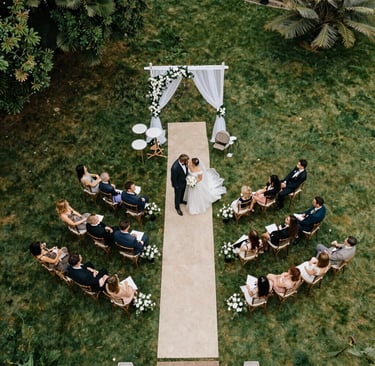 A bride and groom walking in front of a house