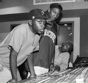 Black and white photo of A Tribe Called Quest members working at a professional recording studio mixing console