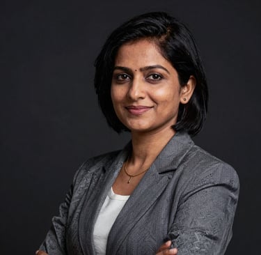 Portrait of a confident woman with short black hair and a warm smile, set against a dark, softly glowing background.