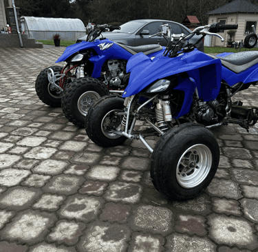 2 blue yamaha yfz450s from 2008 with paddle tires and knobby tires
