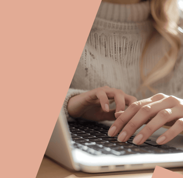 a woman's hands typing on a laptop computer