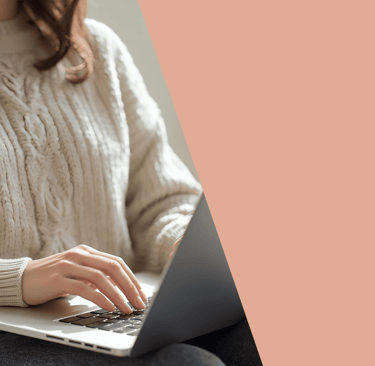 a woman sitting on a couch using a laptop