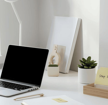 a laptop computer sitting on a desk with a note pad