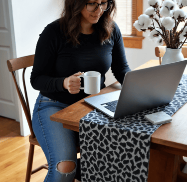 a woman sitting at a table with a cup of coffee