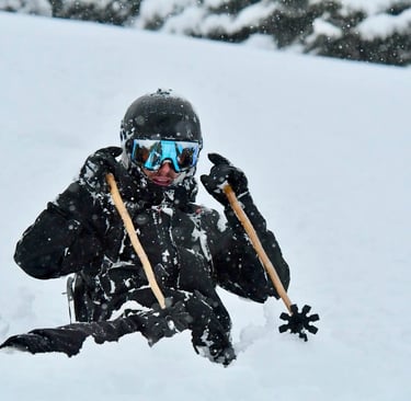 skieur enfoncé dans la poudreuse avec batons de ski en bambou