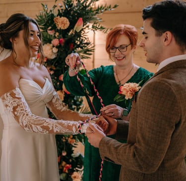 A wedding couple taking part in a handfasting ceremony