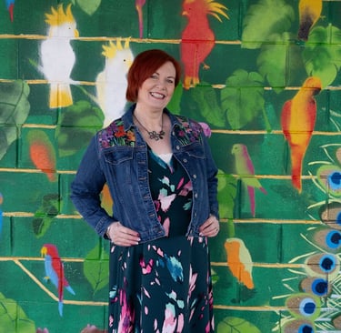 Dawn Vincent Celebrant standing in front of a colour mural