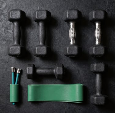 A vibrant coral dumbbell resting on a white workout mat with a sage green water bottle nearby.