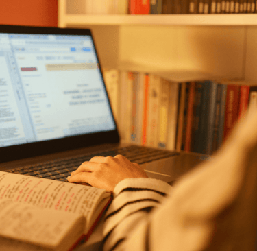 a person sitting at a desk with a book and a book