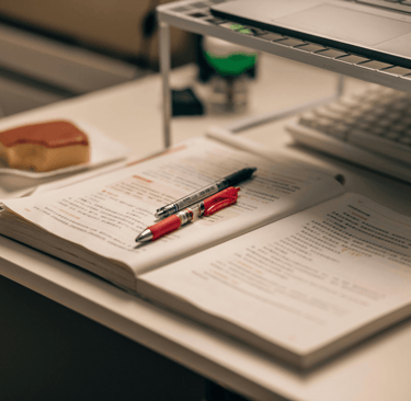 a laptop computer and a pen on a desk
