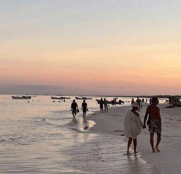 Die Geschichte vom Fischer und dem Geschäftsmann. Strand mit Fischerbooten im Hintergrund.