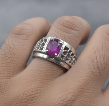 Elegant men's silver ring featuring an oval-cut purple ruby gemstone and intricate filigree design.