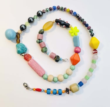 Handmade eclectic beaded necklace with colorful glass, gemstone, and acrylic beads in a spiral layout.