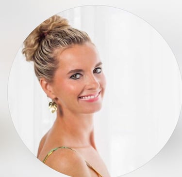 Smiling woman with blonde curly hair in a bun wearing gold leaf earrings in a professional circular headshot.