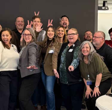 Providence Supply Chain colleagues posing for a fun team photo in a conference room.