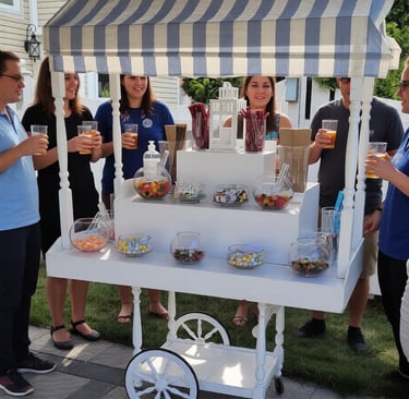Guests gather around a white vintage candy cart with blue striped awning at an outdoor event.