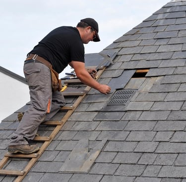 Roofing Specialists Yorkshire. Roofer repairing damaged roof tiles