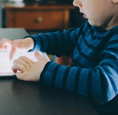 un enfant joue avec une tablette
