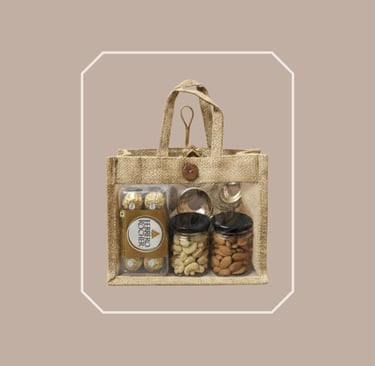 Sustainable jute tote gourmet food hamper with chocolates and dry fruit jars.