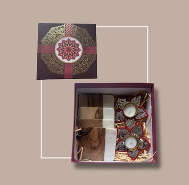 Deep red festive gifting set with a mandala lid, treats, and a floral t-light diya.