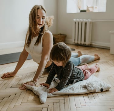 a woman and her daughter playing with a pillow