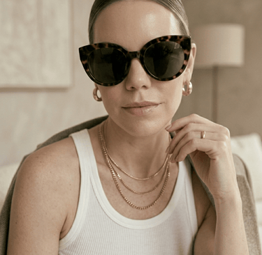 Minimal gold jewelry and sunglasses styled with clean girl fashion essentials