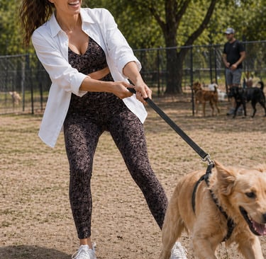 Casual athleisure outfit for women at a dog park pulling on a leash while wearing patterned leggings