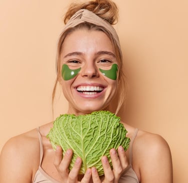 a smiling woman with a vegetable mask on her face and a cabbage leaf in her hands
