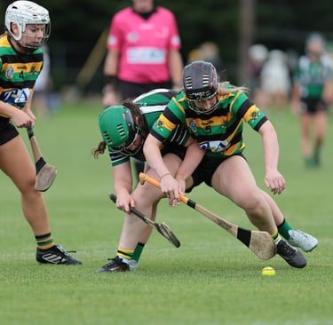 Camogie players battling for the sliotar on the ground
