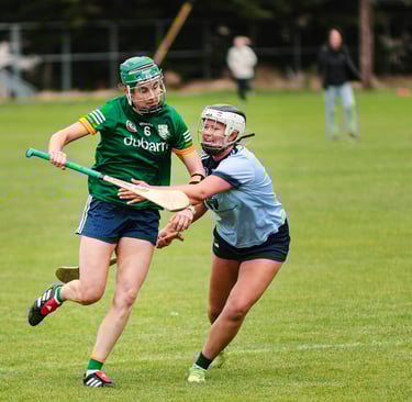 Camogie player breaking through a tackle