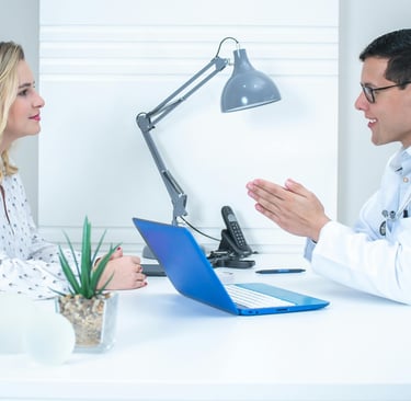 Arzt mit Patientin am Schreibtisch, Diskutieren  