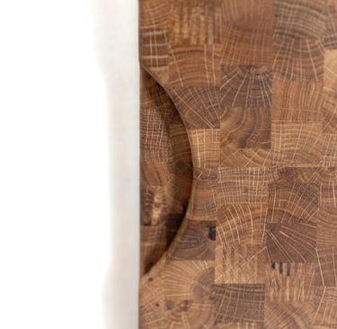 Close-up of the recessed handle and end-grain pattern of a wooden chopping board