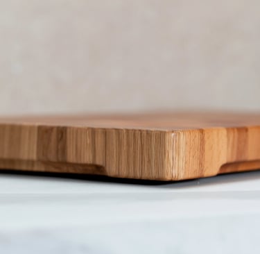 Close-up of a thick end-grain wooden chopping board showing its rounded edge