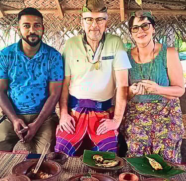Tourists wearing Sri Lankan traditional attire during a cultural experience with their driver.