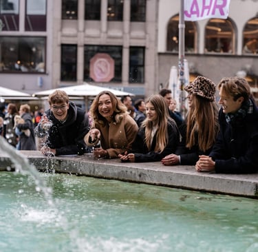 a group of people sitting around a fountain