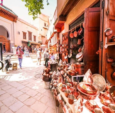 Busy street in Moroccan medina with traditional copper crafts and local shops