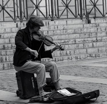 a man playing a violin on a suitcase