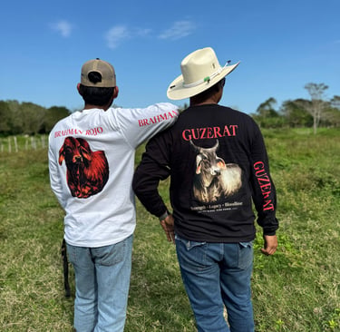 Two men wearing long-sleeve shirts featuring Brahman and Guzerat cattle designs in a grassy field.