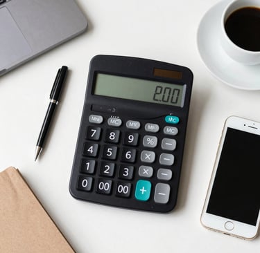 Desktop workspace with a black calculator, smartphone, and coffee cup for financial planning.