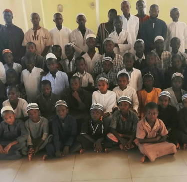 a group of people standing around a group of children