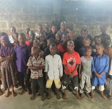a group of children and adults posing for a group photo west africa