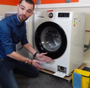 un homme montre comment nettoyer le filtre de sa machine à laver